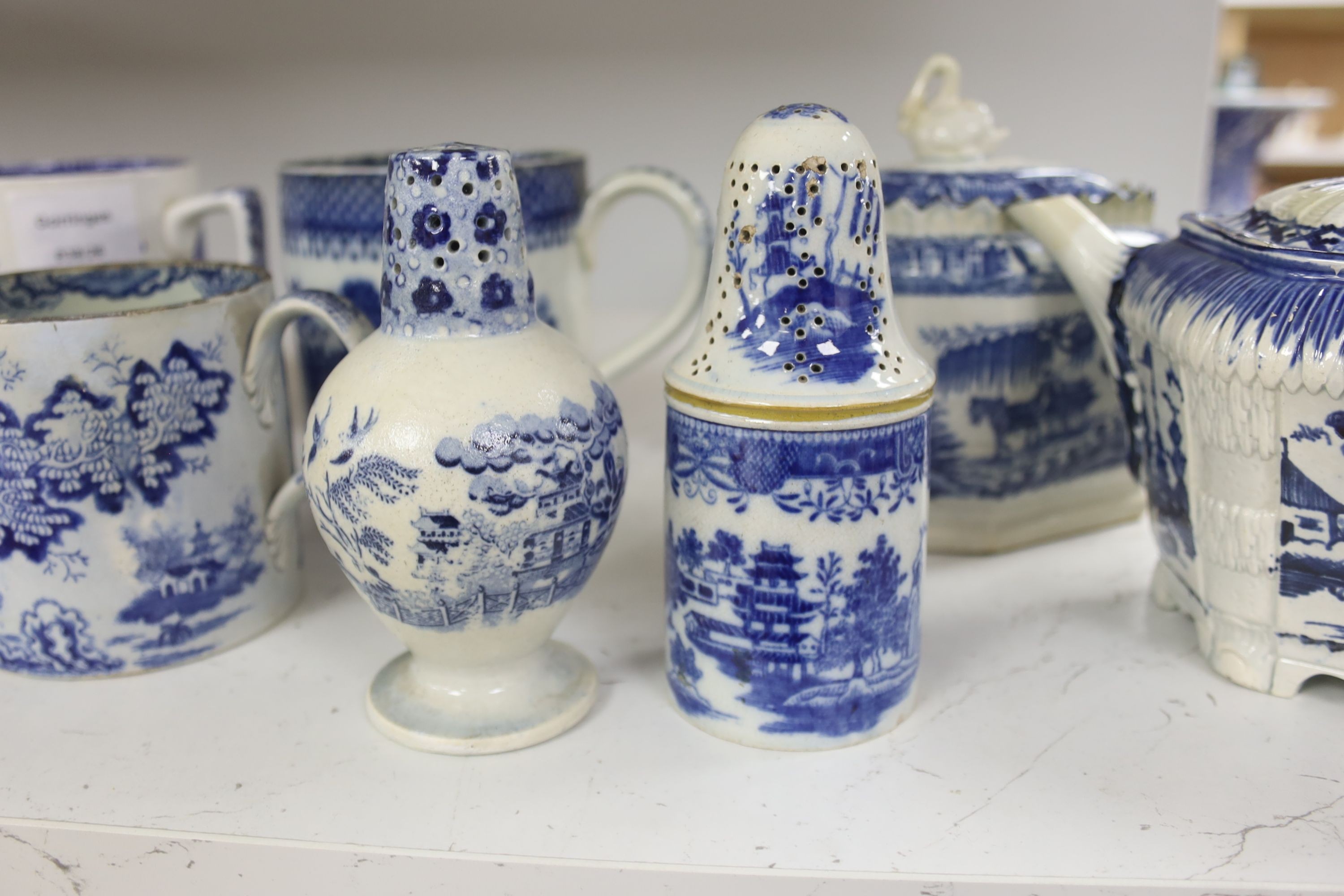 A collection of English blue and white pottery, various dates, comprising a moulded hexagonal teapot and cover, with widow finial, ovoid teapot and cover, lozenge section sugar bowl and cover, with swan finial, circular